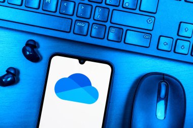 Prag, Çek Cumhuriyeti - 08 09 2025: OneDrive logosunu gösteren bir telefonun olduğu bir masanın yukarıdan görünüşü. OneDrive dosyaları kaydetmek ve paylaşmak için bir bulut depolama platformudur.