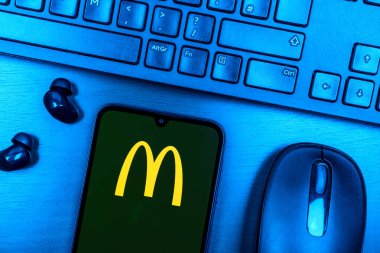 Prague, Czechia - 08 09 2025: A top-down view of a desk with a phone displaying the McDonalds logo. McDonalds is a fast-food chain serving burgers, fries, and more.
