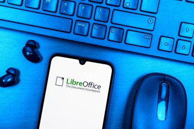 Prague, Czechia - 08 09 2025: A top-down view of a desk with a phone displaying the LibreOffice logo. LibreOffice is a free software suite for creating documents, spreadsheets, and presentations.