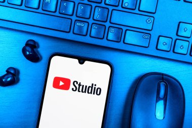 Prague, Czechia - 08 09 2025: A top-down view of a desk with a phone displaying the Youtube Studio logo. Youtube Studio is a platform for managing and analyzing YouTube channels.