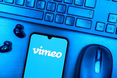 Prague, Czechia - 08 09 2025: A top-down view of a desk with a phone displaying the Vimeo logo. Vimeo is a platform for hosting and sharing high-quality videos.