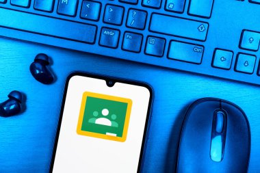 Prague, Czechia - 08 09 2025: A top-down view of a desk with a phone displaying the Google Classroom logo. Google Classroom is a platform for managing classes and educational content.