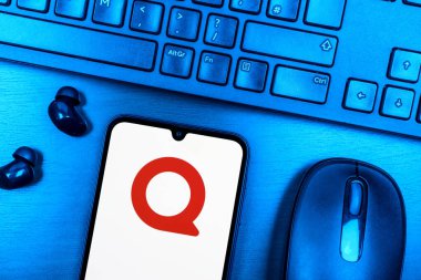 Prague, Czechia - 08 09 2025: A top-down view of a desk with a phone displaying the Quora logo. Quora is a platform for asking questions and sharing knowledge.