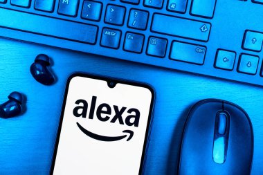 Prague, Czechia - 08 09 2025: A top-down view of a desk with a phone displaying the Alexa logo. Alexa is a voice assistant for smart devices and services.