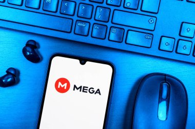 Prague, Czechia - 08 09 2025: A top-down view of a desk with a phone displaying the Mega logo. Mega is a platform for cloud storage with encrypted file sharing.