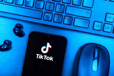 Prague, Czechia - 08 09 2025: A top-down view of a desk with a phone displaying the TikTok logo. TikTok is a platform for short, creative, and viral videos.