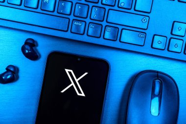 Prag, Çek Cumhuriyeti - 08 09 2025: X logosunu gösteren bir telefonun olduğu bir masanın yukarıdan görünüşü. X, kısa gönderileri ve güncellemeleri paylaşmak için bir platformdur.