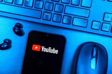 Prag, Çek Cumhuriyeti - 08 09 2025: Youtube logosunu gösteren bir telefonun olduğu bir masanın yukarıdan görünüşü. Youtube dünya çapında videoları izlemek ve paylaşmak için bir platform.