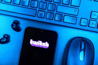Prague, Czechia - 08 09 2025: A top-down view of a desk with a phone displaying the Twitch logo. Twitch is a platform for live streaming games and content.