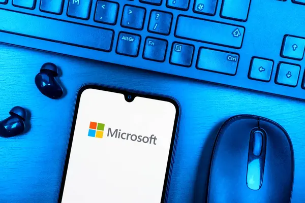 Prag, Çek Cumhuriyeti - 08 09 2025: Microsoft logosunu gösteren bir telefonun olduğu bir masanın yukarıdan görünüşü. Microsoft yazılım, donanım ve hizmet sunan bir teknoloji şirketidir..