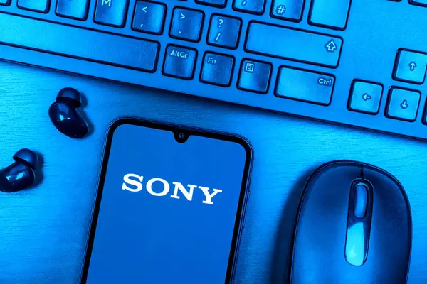 Prague, Czechia - 08 09 2025: A top-down view of a desk with a phone displaying the Sony logo. Sony is a tech company producing electronics, games, and entertainment.