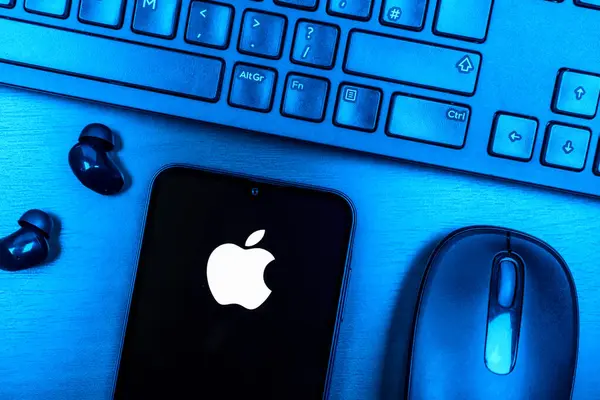 Prague, Czechia - 08 09 2025: A top-down view of a desk with a phone displaying the Apple logo. Apple is a technology company making iPhones, computers, and services.