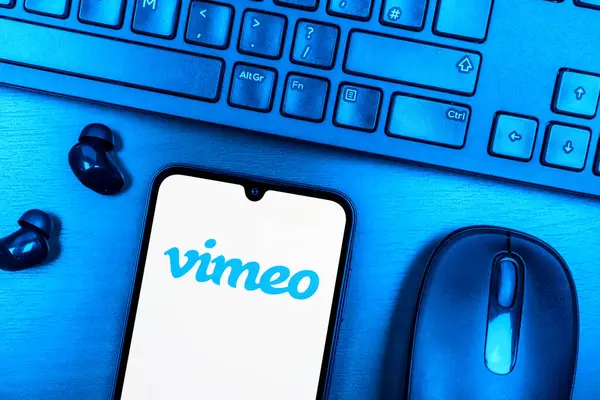 Prague, Czechia - 08 09 2025: A top-down view of a desk with a phone displaying the Vimeo logo. Vimeo is a platform for hosting and sharing high-quality videos.