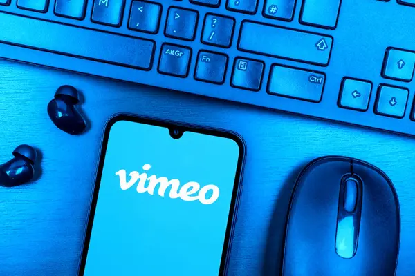 Prague, Czechia - 08 09 2025: A top-down view of a desk with a phone displaying the Vimeo logo. Vimeo is a platform for hosting and sharing high-quality videos.
