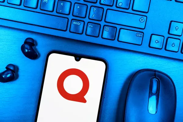 Prague, Czechia - 08 09 2025: A top-down view of a desk with a phone displaying the Quora logo. Quora is a platform for asking questions and sharing knowledge.