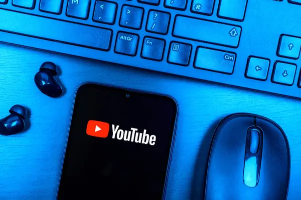Prag, Çek Cumhuriyeti - 08 09 2025: Youtube logosunu gösteren bir telefonun olduğu bir masanın yukarıdan görünüşü. Youtube dünya çapında videoları izlemek ve paylaşmak için bir platform.