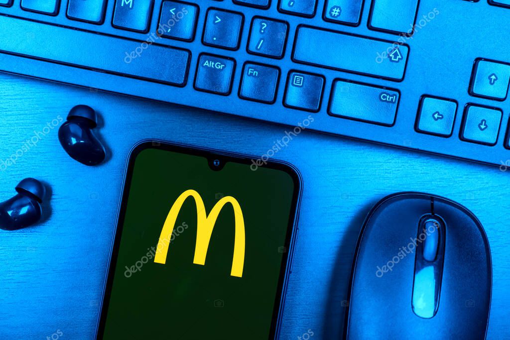Prague, Czechia - 08 09 2025: A top-down view of a desk with a phone displaying the McDonalds logo. McDonalds is a fast-food chain serving burgers, fries, and more.