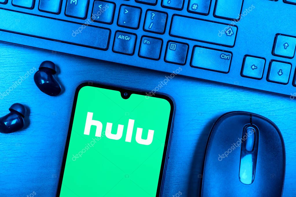 Prague, Czechia - 08 09 2025: A top-down view of a desk with a phone displaying the Hulu logo. Hulu is a streaming platform for TV shows, movies, and live TV.