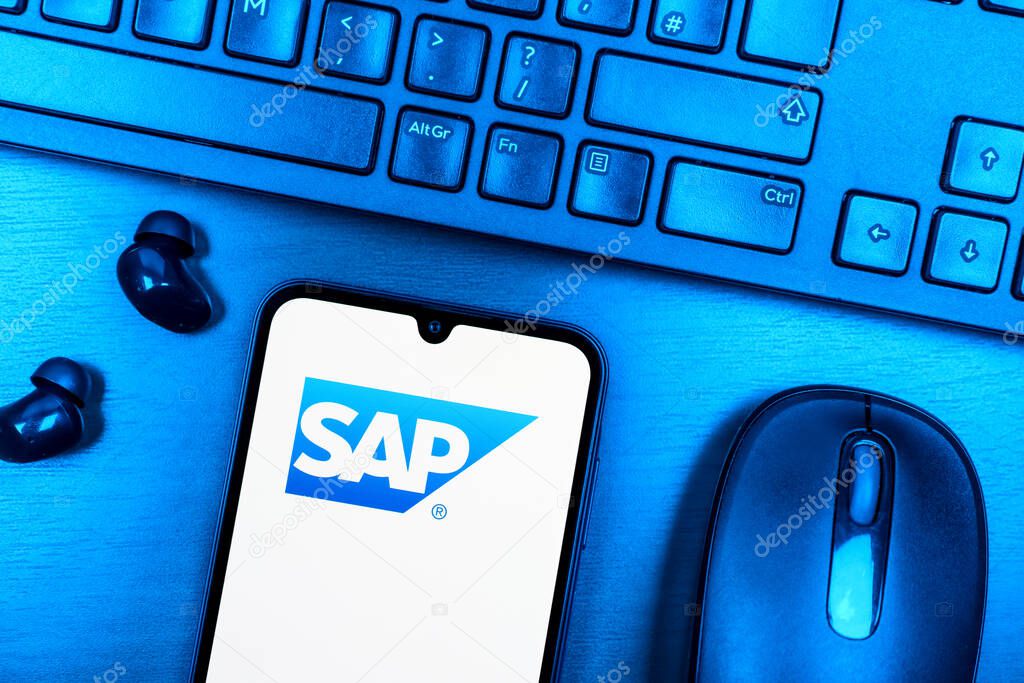 Prague, Czechia - 08 09 2025: A top-down view of a desk with a phone displaying the SAP logo. SAP is a software company providing enterprise applications and solutions.