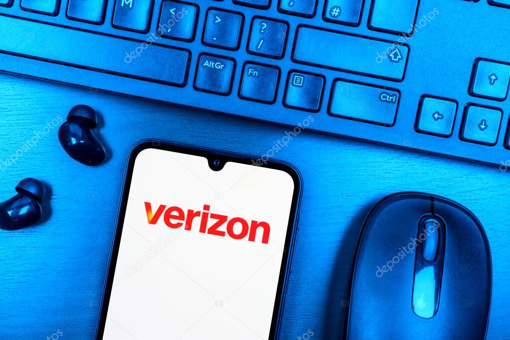 Prague, Czechia - 08 09 2025: A top-down view of a desk with a phone displaying the Verizon logo. Verizon is a telecom company providing wireless and broadband services.