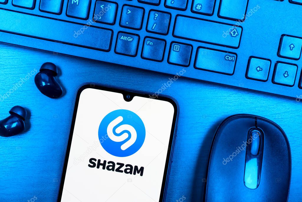 Prague, Czechia - 08 09 2025: A top-down view of a desk with a phone displaying the Shazam logo. Shazam is an app for identifying songs and music tracks.