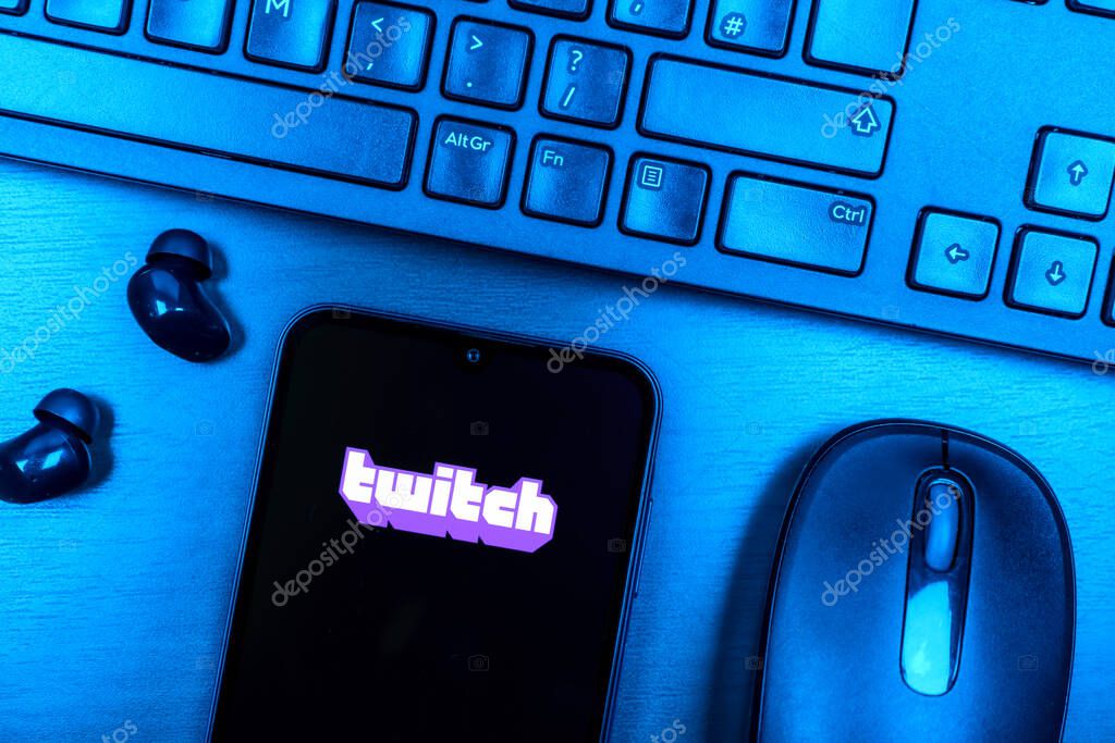 Prague, Czechia - 08 09 2025: A top-down view of a desk with a phone displaying the Twitch logo. Twitch is a platform for live streaming games and content.