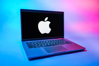Prag, Çek Cumhuriyeti - 08 01 2025: Uniforma arka planda bir dizüstü bilgisayar Apple logosunu gösterir. Apple iPhone, bilgisayar ve hizmet üreten bir teknoloji şirketidir..