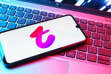 Prag, Çek Cumhuriyeti - 08 01 2025: Dizüstü bilgisayarın üzerinde duran bir cep telefonu Tango logosunu gösteriyor. Tango, görüntülü aramalar, mesajlar ve canlı yayınlar için sosyal bir uygulama..