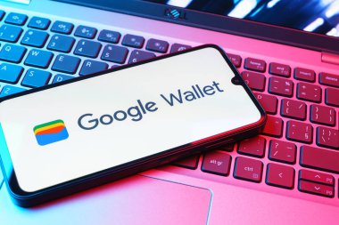 Prag, Çek Cumhuriyeti - 08 01 2025: Dizüstü bilgisayarda bulunan bir cep telefonu Google Cüzdan logosunu görüntüler. Google Cüzdanı dijital ödeme yöntemlerini depolamak ve kullanmak için bir platformdur.