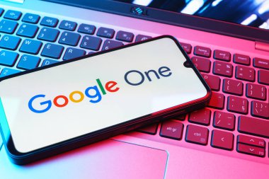 Prag, Çek Cumhuriyeti - 08 01 2025: Dizüstü bilgisayarda bulunan bir cep telefonu Google One logosunu görüntüler. Google 1 bulut depolama ve abonelik hizmetleri için bir platformdur.