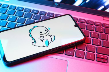 Prag, Çek Cumhuriyeti - 08 01 2025: Dizüstü bilgisayarın üzerinde duran bir cep telefonu Bigo Live logosunu gösteriyor. Bigo Live canlı yayın ve sosyal etkileşim için bir platformdur.