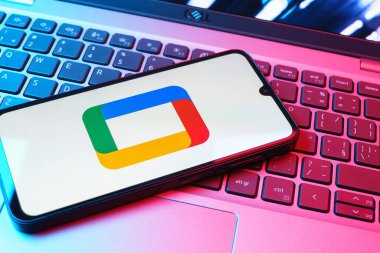 Prag, Çek Cumhuriyeti - 08 01 2025: Laptop klavyesinde uzanan bir cep telefonu Google TV logosunu gösteriyor. Google TV film, program ve uygulamalar için bir platformdur..