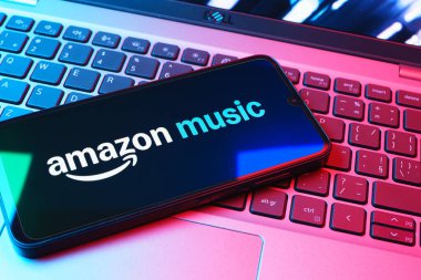 Prag, Çek Cumhuriyeti - 08 01 2025: Laptop klavyesinde uzanan bir cep telefonu Amazon Müzik logosunu gösteriyor. Amazon Müzik müzik müzik için bir platformdur..