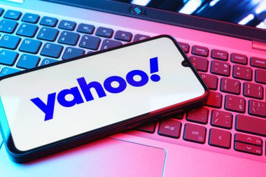 Prag, Çek Cumhuriyeti - 08 01 2025: Laptop klavyesinde duran bir cep telefonu Yahoo logosunu gösteriyor. Yahoo haber, e-posta ve internet hizmetleri için bir platformdur..