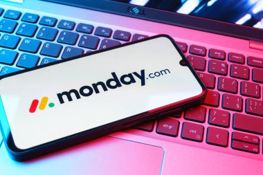 Prag, Çek Cumhuriyeti - 08 01 2025: Laptop klavyesinde duran bir cep telefonu Monday.com logosunu gösteriyor. Monday.com proje yönetimi ve takım işbirliği için bir platformdur.