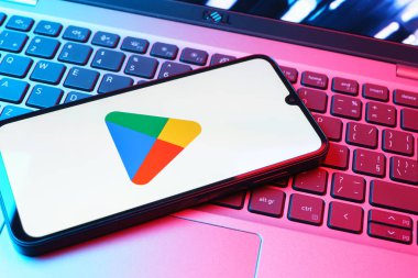 Prag, Çek Cumhuriyeti - 08 01 2025: Dizüstü bilgisayarda bulunan bir cep telefonu Google Play logosunu görüntüler. Google Play uygulamaları, oyunları ve dijital içeriği indirmek için bir platformdur.