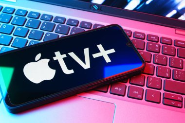 Prag, Çek Cumhuriyeti - 08 01 2025: Laptop klavyesinde uzanan bir cep telefonu Apple TV + logosunu gösteriyor. Apple TV +, filmler ve TV programları için bir yayın platformudur..