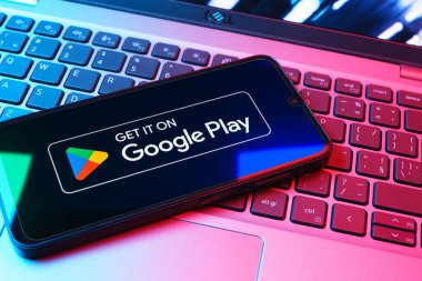 Prag, Çek Cumhuriyeti - 08 01 2025: Dizüstü bilgisayarda bulunan bir cep telefonu Google Play logosunu görüntüler. Google Play uygulamaları, oyunları ve dijital içeriği indirmek için bir platformdur.