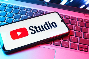 Prag, Çek Cumhuriyeti - 08 01 2025: Laptop klavyesinde duran bir cep telefonu Youtube Stüdyo logosunu görüntüler. Youtube Studio YouTube kanallarını yönetmek ve analiz etmek için bir platformdur.