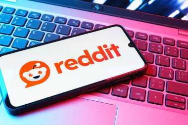 Prag, Çek Cumhuriyeti - 08 01 2025: Dizüstü bilgisayarın üzerinde duran bir cep telefonu Reddit logosunu gösterir. Reddit tartışma, haber ve toplum içeriği için bir platformdur.