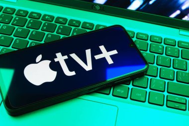 Prag, Çek Cumhuriyeti - 08 01 2025: Laptop klavyesinde uzanan bir cep telefonu Apple TV + logosunu gösteriyor. Apple TV +, filmler ve TV programları için bir yayın platformudur..