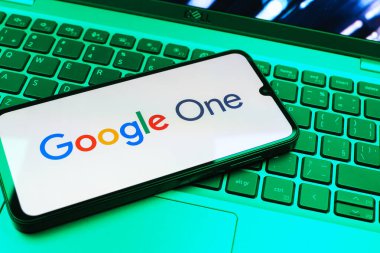 Prag, Çek Cumhuriyeti - 08 01 2025: Dizüstü bilgisayarda bulunan bir cep telefonu Google One logosunu görüntüler. Google 1 bulut depolama ve abonelik hizmetleri için bir platformdur.