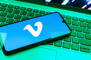 Prag, Çek Cumhuriyeti - 08 01 2025: Dizüstü bilgisayarın üzerinde duran bir cep telefonu Vimeo logosunu gösterir. Vimeo, yüksek kaliteli video sunucu ve paylaşımı için bir platformdur.