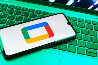 Prag, Çek Cumhuriyeti - 08 01 2025: Laptop klavyesinde uzanan bir cep telefonu Google TV logosunu gösteriyor. Google TV film, program ve uygulamalar için bir platformdur..