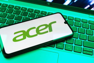 Prag, Çek Cumhuriyeti - 08 01 2025: Dizüstü bilgisayarın üzerinde duran bir cep telefonu Acer logosunu gösterir. Acer bilgisayar ve elektronik üreten bir teknoloji şirketidir..