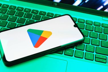 Prag, Çek Cumhuriyeti - 08 01 2025: Dizüstü bilgisayarda bulunan bir cep telefonu Google Play logosunu görüntüler. Google Play uygulamaları, oyunları ve dijital içeriği indirmek için bir platformdur.
