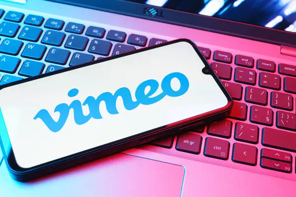 Prag, Çek Cumhuriyeti - 08 01 2025: Dizüstü bilgisayarın üzerinde duran bir cep telefonu Vimeo logosunu gösterir. Vimeo, yüksek kaliteli video sunucu ve paylaşımı için bir platformdur.