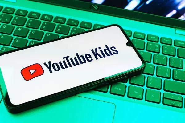 Prag, Çek Cumhuriyeti - 08 01 2025: Laptop klavyesinde duran bir cep telefonu Youtube Kids logosunu gösteriyor. Youtube Kids çocuk dostu video içeriği için bir platformdur.