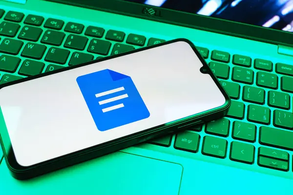 Prag, Çek Cumhuriyeti - 08 01 2025: Dizüstü bilgisayarda bulunan bir cep telefonu Google Docs logosunu görüntüler. Google Docs metin belgeleri oluşturmak ve düzenlemek için bir platformdur.