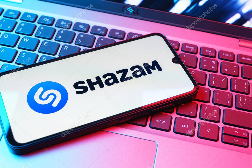 Prague, Czechia - 08 01 2025: A mobile phone lying on a laptop keyboard displays the Shazam logo. Shazam is an app for identifying songs and music tracks.